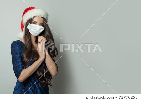 Attractive Christmas woman wearing protective medical mask Attractive Christmas woman wearing protective medical mask 72776255