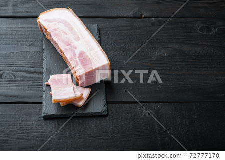 Bacon pancetta cut and sliced on black wooden table with space for text Bacon pancetta cut and sliced on black wooden table with space for text 72777170