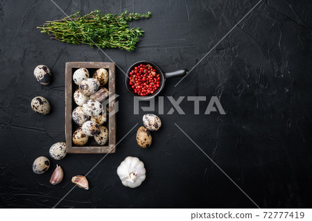 Fresh quail eggs, flat lay, on black textured background with space for text 72777419