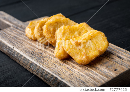 Chicken breast nuggets on black wooden background Chicken breast nuggets on black wooden background 72777423