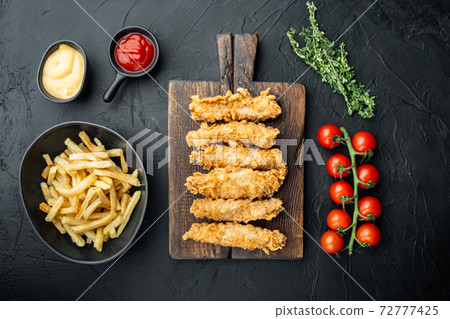 Chicken breaded fillet on black background, flat lay Chicken breaded fillet on black background, flat lay 72777425