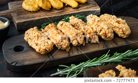 Breaded chicken wings on old dark wooden table Breaded chicken wings on old dark wooden table 72777473