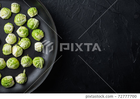 Brussels sprouts, on black textured background, top view with space for text 72777700