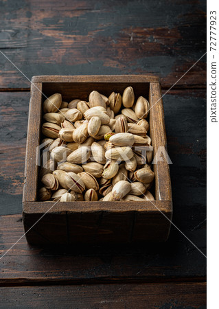 Shelled unsalted pistachios, on old wooden table, top view Shelled unsalted pistachios, on old wooden table, top view 72777923