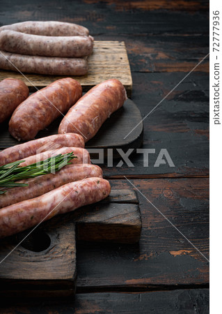 Traditional raw beef sausages, on old dark wooden background 72777936