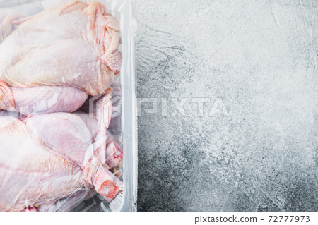 Plastic container with raw chicken, on gray background, top view with copy space for text 72777973