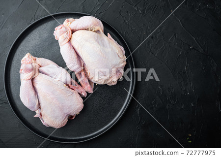 Organic whole poussins, on black background, top view with copy space for text Organic whole poussins, on black background, top view with copy space for text 72777975