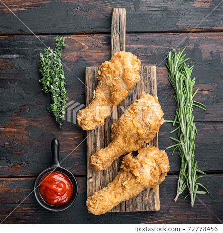 Breaded kentucky chicken drumctick on dark wooden background, flat lay 72778456