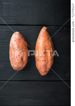 Raw whole sweet potatoe, on black wooden background, flat lay with copyspace 72778527