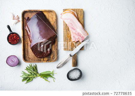 Raw beef liver with smoked bacon on white background, flat lay with copy space Raw beef liver with smoked bacon on white background, flat lay with copy space 72778635