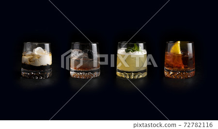 Set of classic cold alcoholic cocktails in transparent glasses on a black background. White Russian, Bramble, Whiskey Sour and Negroni. Set of classic cold alcoholic cocktails in transparent glasses on a black background. White Russian, Bramble, Whiskey Sour and Negroni. 72782116