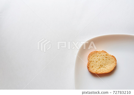 A rusk placed on a white plate 72783210