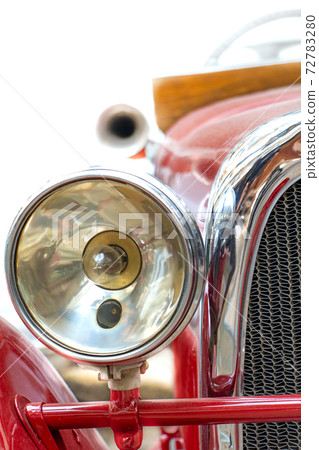 The headlight of the old car. Veteran car with large chrome light,close up. Front mask of retro car. 72783280