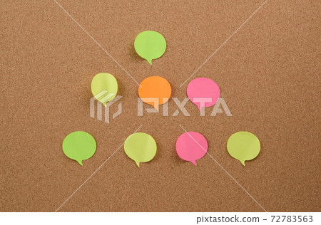 multicolored round sticks are glued to the brown cork board 72783563