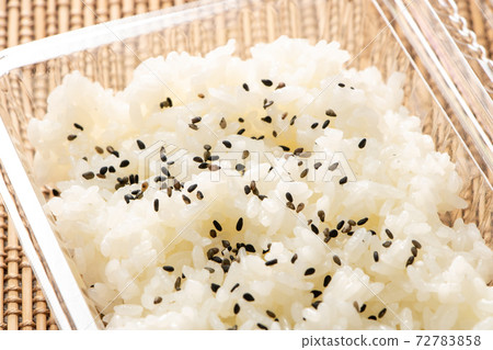 Rice sprinkled with salt and pepper in a take-out container. 72783858