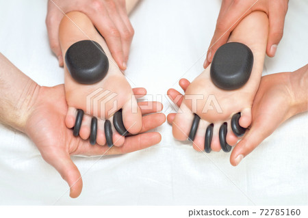 Massage stones between on feet. Massage stones between on feet. 72785160