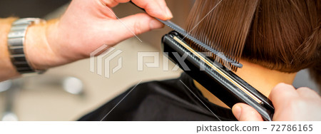 Hairdresser straightening the short hair 72786165