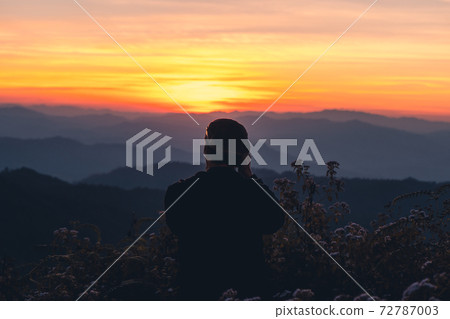 A photographer taking a picture of the sunset A photographer taking a picture of the sunset 72787003