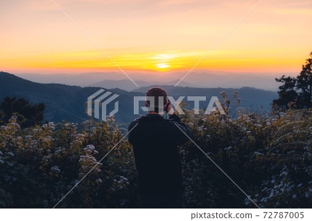 A photographer taking a picture of the sunset A photographer taking a picture of the sunset 72787005