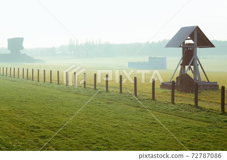 grass field with barbed wire fence and Peace bell in German concentration and extermination camp Majdanek. Lublin, Poland grass field with barbed wire fence and Peace bell in German concentration and extermination camp Majdanek. Lublin, Poland 72787086