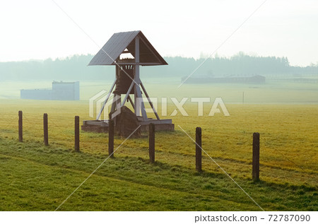 barbed wire fence and Peace bell in German concentration and extermination camp Majdanek. Lublin, Poland 72787090