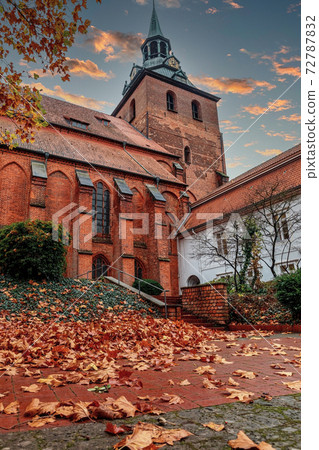 Church of St. Michaelis in the old town of Luneburg in an autumn day, yellow leaves in the foreground Church of St. Michaelis in the old town of Luneburg in an autumn day, yellow leaves in the foreground 72787832