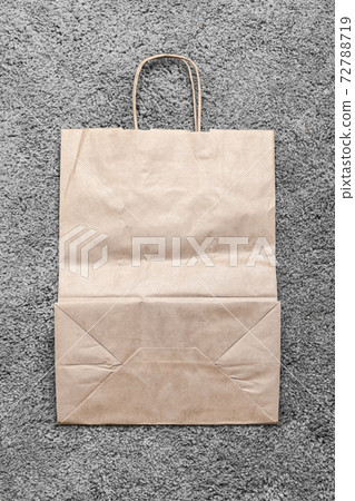 Empty flat recycling paper bag lays on a gray carpet Empty flat recycling paper bag lays on a gray carpet 72788719