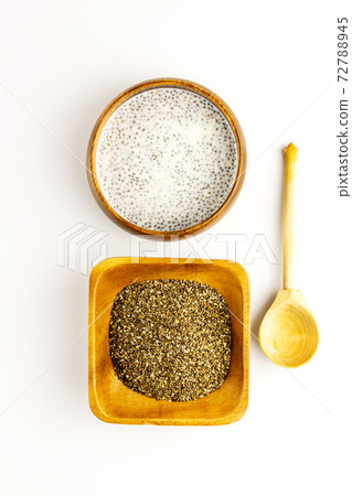Chia seed milk pudding and dry seeds in bamboo bowls with wooden rustic spoon. Top view. Flat lay 72788945