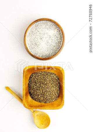 Chia seed milk pudding and dry seeds in bamboo bowls with wooden rustic spoon. Top view. Flat lay 72788946