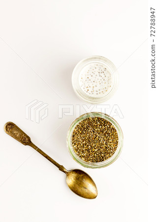 Chia seed milk pudding and dry seeds in small glass bowls with vintage spoon. Top view. Flat lay 72788947