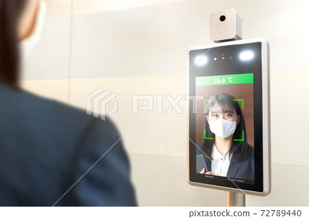 Business woman measuring temperature with a thermal camera Business woman measuring temperature with a thermal camera 72789440