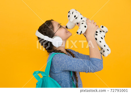 Cute smiling schoolgirl carry soft toy dog. Girl little schoolgirl. Cute smiling schoolgirl carry soft toy dog. Girl little schoolgirl. 72791001
