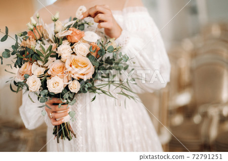 wedding bouquet with peonies in the hands of the bride under the veil.Morning of the bride 72791251
