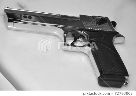 Chrome metal gun on white marble, powerful weapon Desert Eagle 72793002