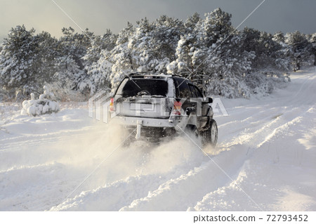 One SUV 4x4 cars go on snowy road, winter season 72793452