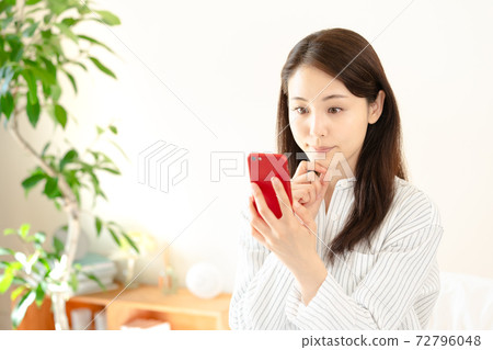 Young woman looking at a smartphone 72796048