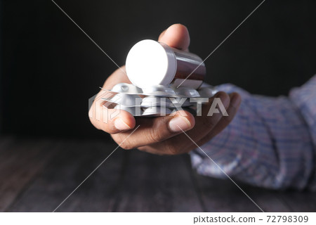 Close up of man hand holding pill container Close up of man hand holding pill container 72798309