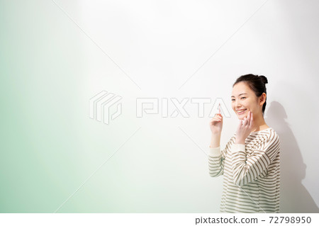 A young woman brushing her teeth A young woman brushing her teeth 72798950