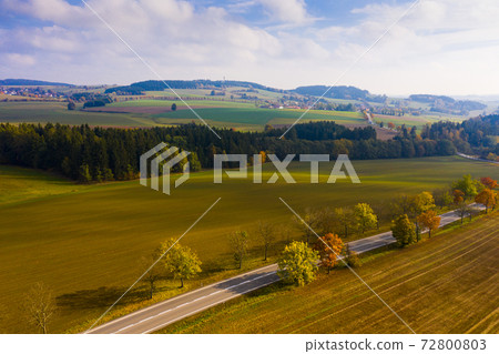 Aerial view of the autumn forest and road between the hills. Czech Republic 72800803