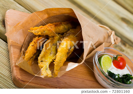 Fried in batter anchovies with creamy cheese sauce and greens 72801160