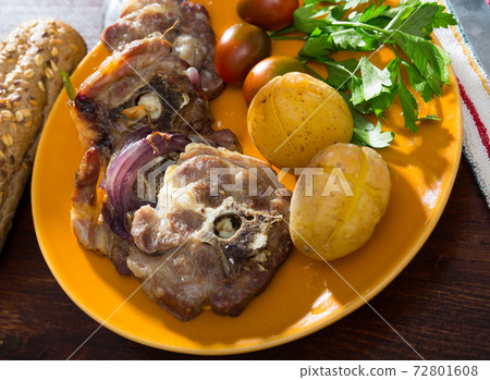 Lamb leg chops with baked potatoes, tomatoes and greens Lamb leg chops with baked potatoes, tomatoes and greens 72801608