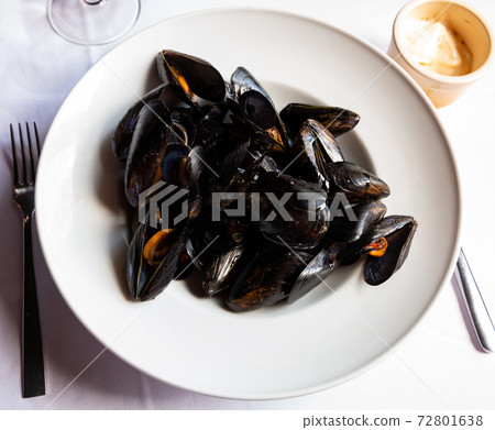 Delicious grilled mussels on plate, served with ali-oli sauce Delicious grilled mussels on plate, served with ali-oli sauce 72801638