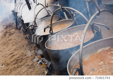 Bowlers with food on bonfire, cooking outdoor in a traditional style 72801743