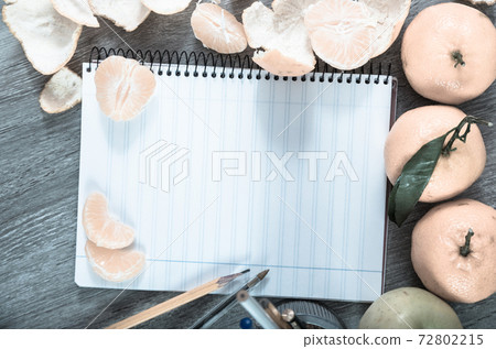 Empty notebook pages and tangerines Empty notebook pages and tangerines 72802215