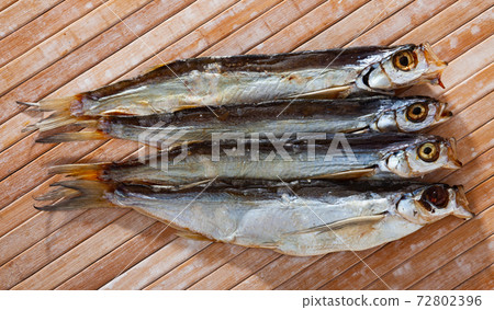 Several dried salted sabrefish on wooden background Several dried salted sabrefish on wooden background 72802396