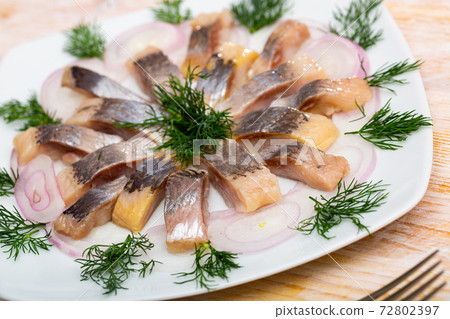 Marinated herring with sliced onion and dill 72802397