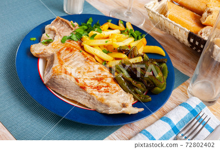 Fried Iberian pig served with potatoes, parsley, stewed pepper 72802402
