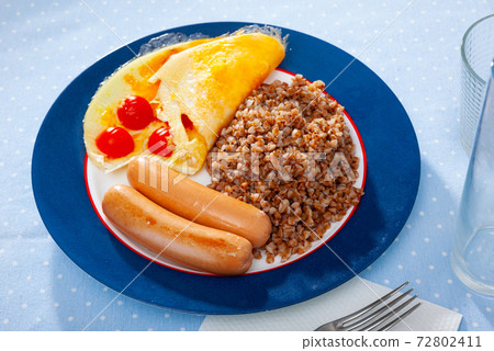 Buckwheat with sausages and omelette with tomatoes Buckwheat with sausages and omelette with tomatoes 72802411