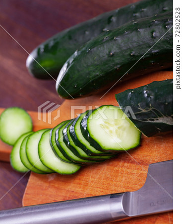 Chopped cucumbers on wooden background 72802528
