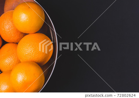 Fresh juicy oranges in a steel bowl in black background.Citrus fruits.Vitamin C fruits Fresh juicy oranges in a steel bowl in black background.Citrus fruits.Vitamin C fruits 72802624